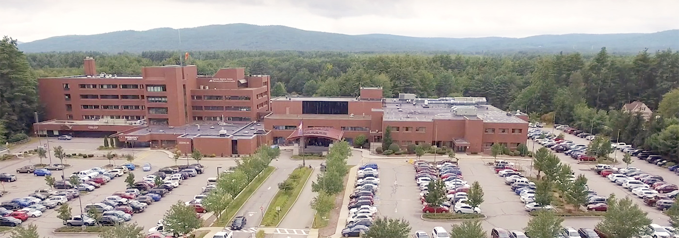 Cheshire Medical Center and parking lots seen from the air with woods and mountains behind it
