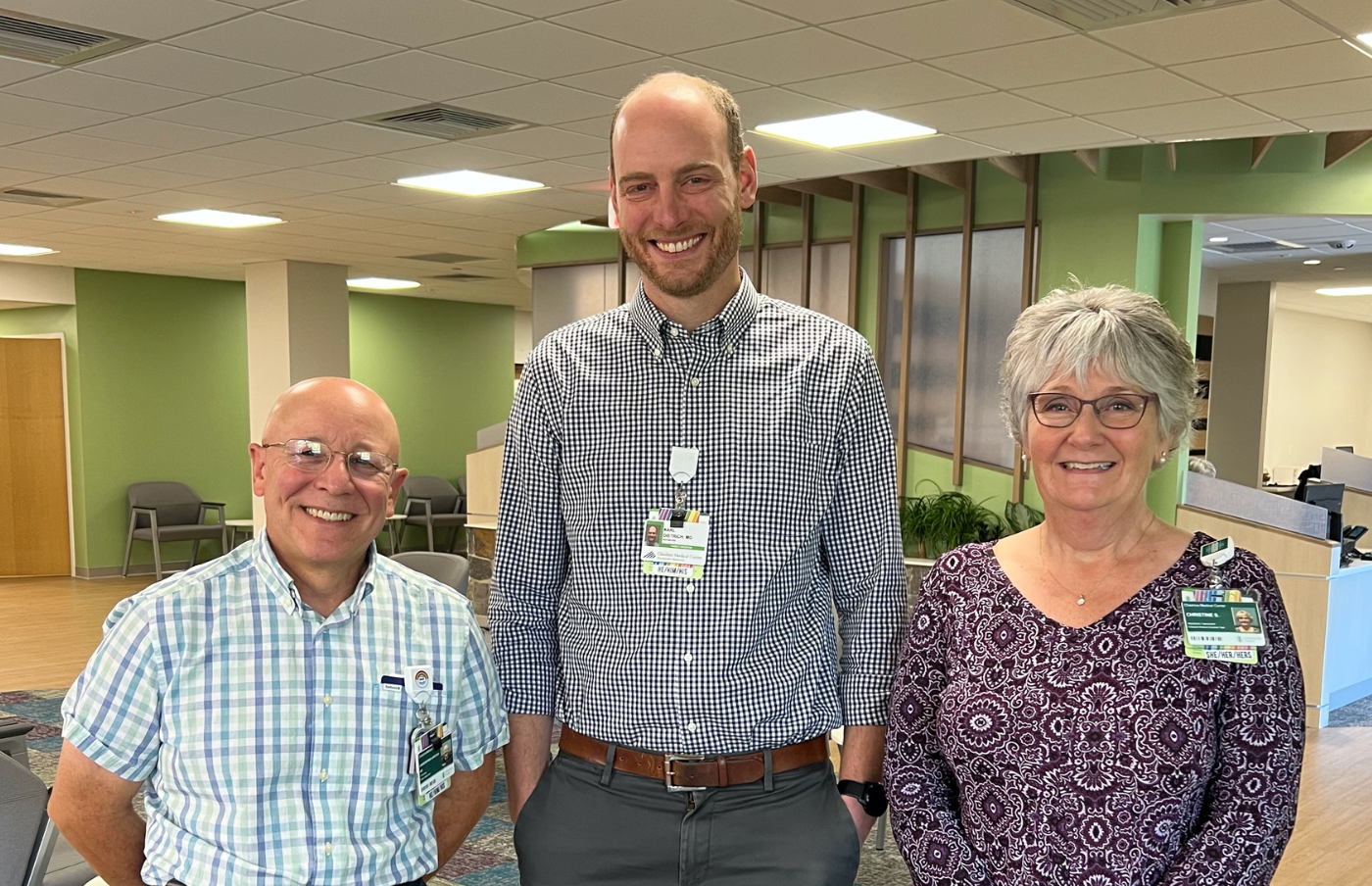 Director of Graduate Medical Education and Family Medicine Residency Development Chris LaRocca, MD, Program Director Karl Dietrich, MD, MPH, and Program Coordinator Christine Symonds gather in Family &Community Care's reception area on Oct. 9, 2023, opening day. 