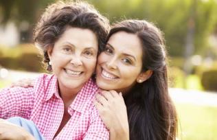 Adult mother and daughter smile at camera