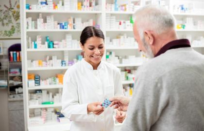 A pharmacist handing medication to a customer