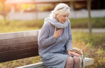 Senior woman clutching chest