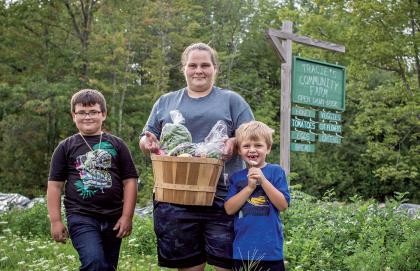 Ashley Rickey-Hale and her sons, Russell and Joshua, pick up a CSA share of fresh vegetables from Tracie’s Community Farm in Fitzwilliam.