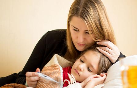 Woman holding a thermometer while comforting a child