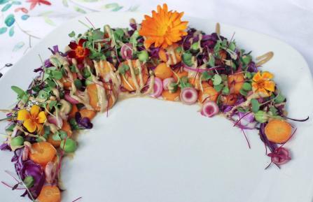 Rainbow summer salad with peanut dressing and garlic scapes