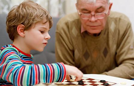 Grandfather and grandson playing checkers