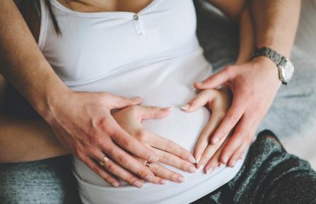 Husband and wife holding wife's pregnant stomach