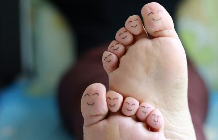 Bare feet with smiley faces on toes