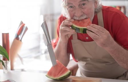 Older man eating watermelon