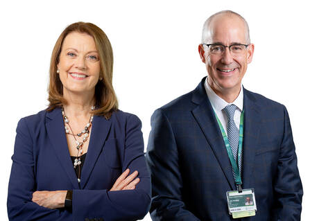 Joanne Conroy and Joe Perras stand shoulder-to-shoulder