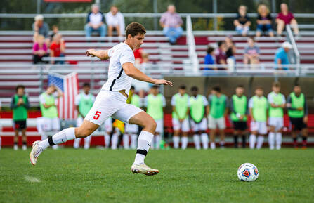 Keene State soccer defenseman Damir Hamzic takes the ball up the field.