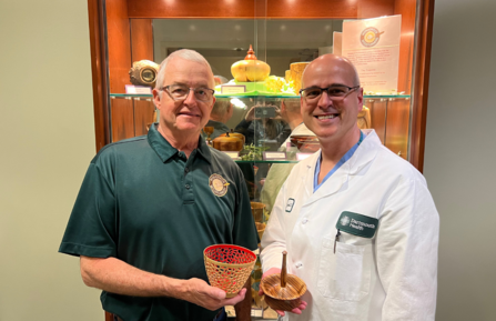 Charles Sheaff and Guy Burman, MD, stand holding their items.