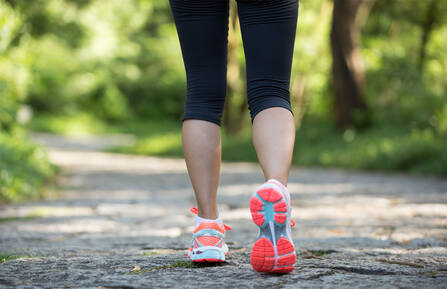 A close-up of a person's walking shoes outside