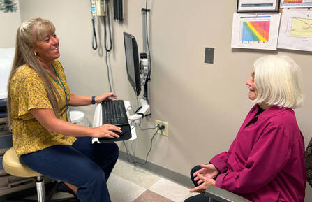 Jennifer Joy, RN, speaks with a patient in an exam room during an Annual Wellness Visit.
