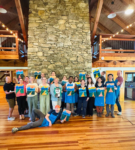 Residents and providers pose with their paintings during the annual Residency Retreat