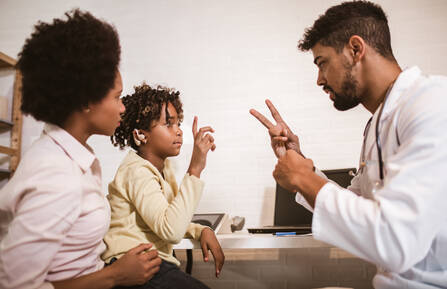 A doctor holding up two fingers to a child