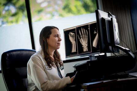 Mia Qin, MD, examines an x-ray