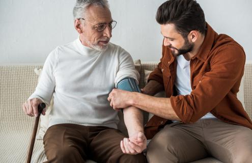 Son administering blood pressure test to father