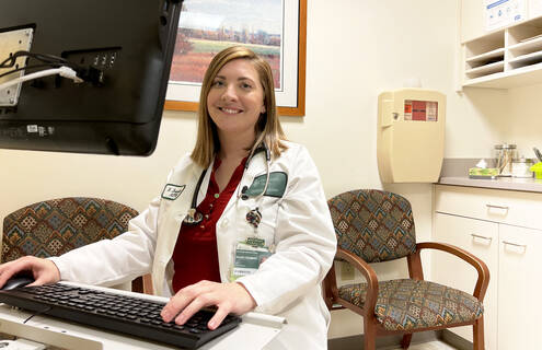 Kelsey Trombley sits at her desk in Cheshire's Family Medicine Department
