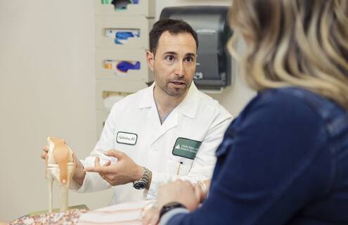 Neal Goldenberg, MD, shows a patient where the ACL is on a model of a knee