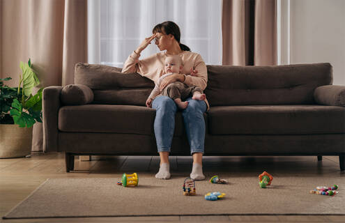 A mother holding her child on the couch