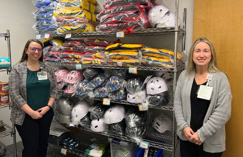 Staff stand in front of resource room item display