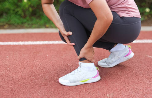 A person grabbing their ankle.