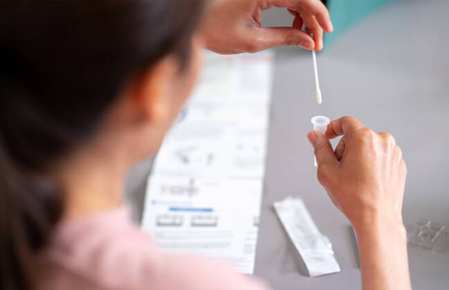 A woman uses an at-home COVID-19 test