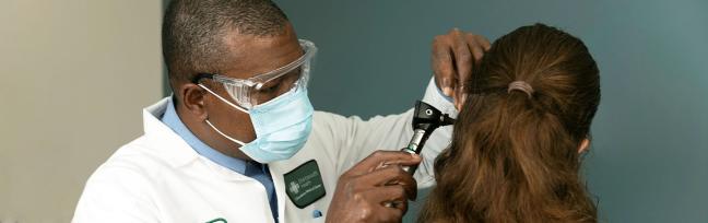Charly Darius, MSN, APRN cares for a small, brunette patient.