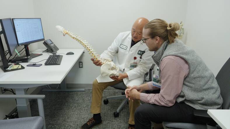 Peter Park, MD, assists Doug Lischke, DO, one of the Family Medicine residents