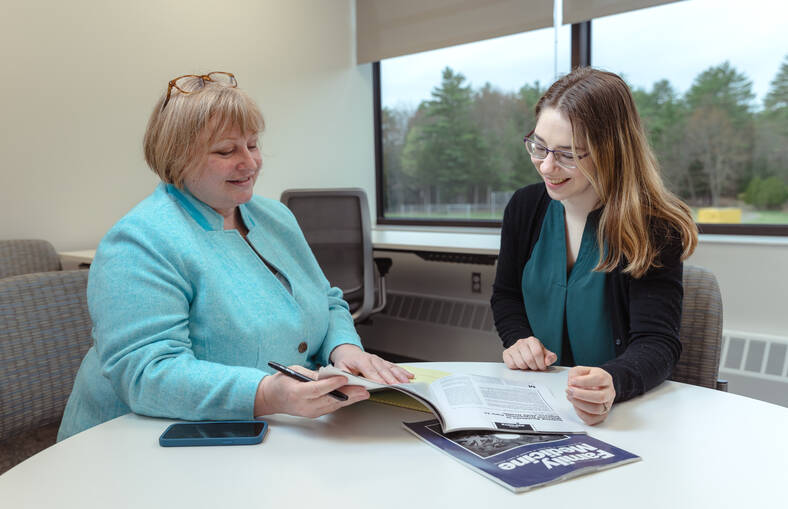 Cathy Schuman looks through a brochure with a resident